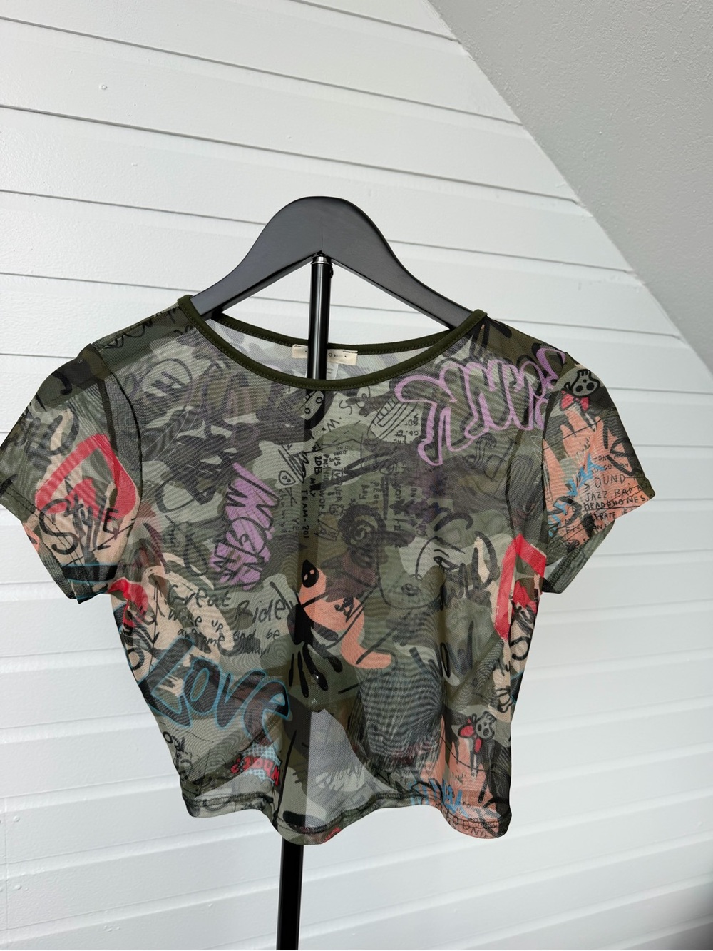 Sheer beauty. 💚 This graffiti-print mesh crop top is serving Y2K attitude